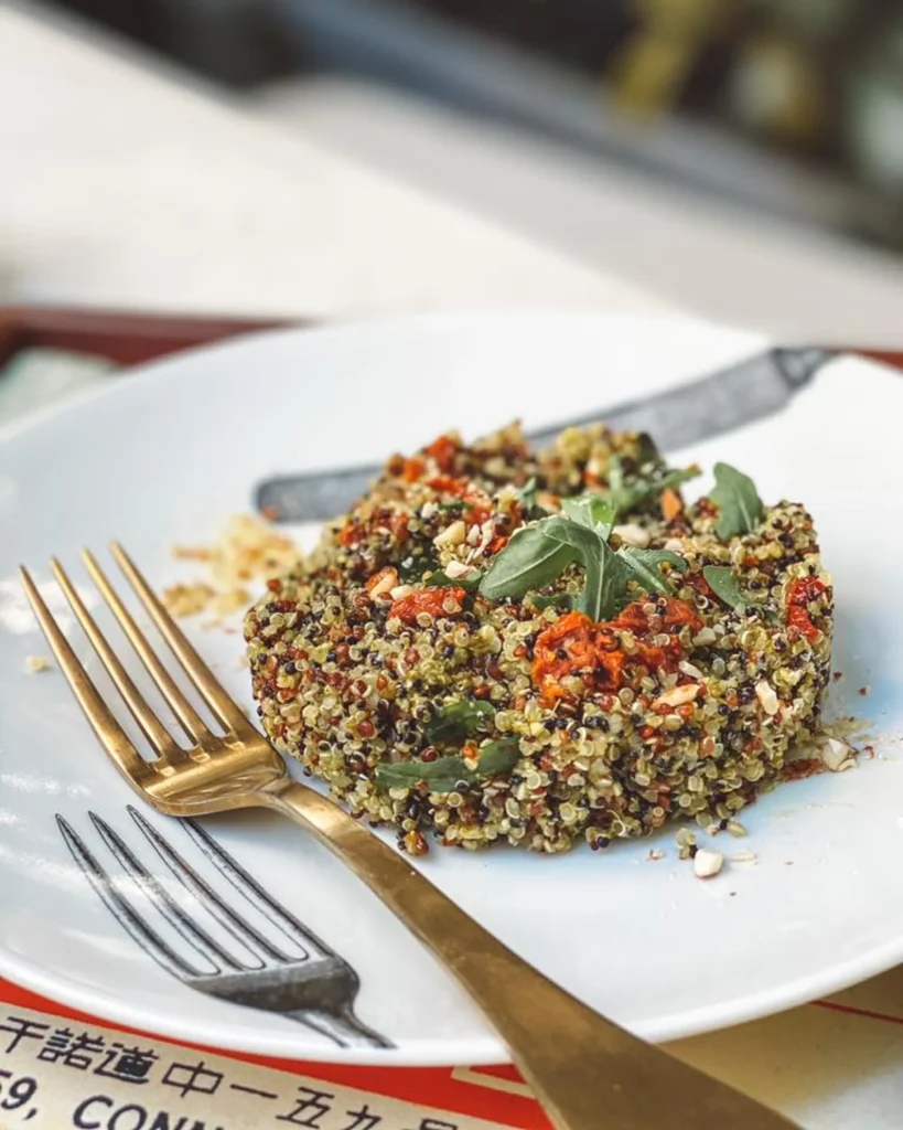 quinoa dish plated with cherry tomatoes and salad