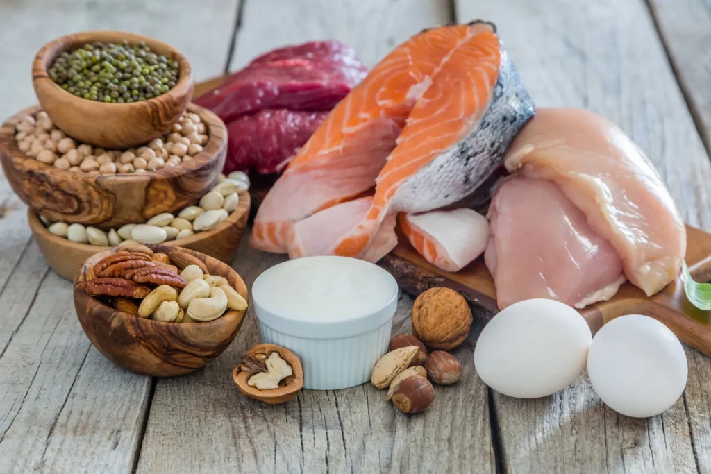 Una mesa repleta de alimentos ricos en proteínas, como carne, pescado, huevos y legumbres