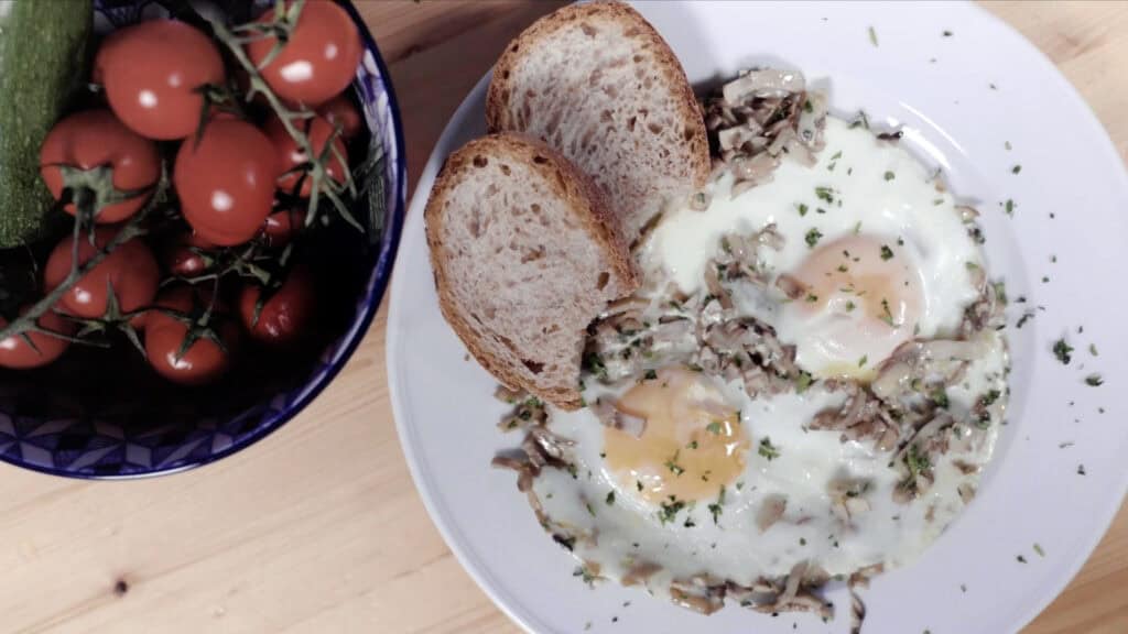 Oeufs aux champignons avec pain complet et tomates fraîches